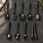 Okura 9-piece utensil set in black arranged on a charcoal kitchen countertop