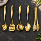 Okura 5-piece utensil set in gold arranged on a charcoal kitchen countertop