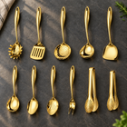 Okura 11-piece utensil set in gold arranged on a charcoal kitchen countertop