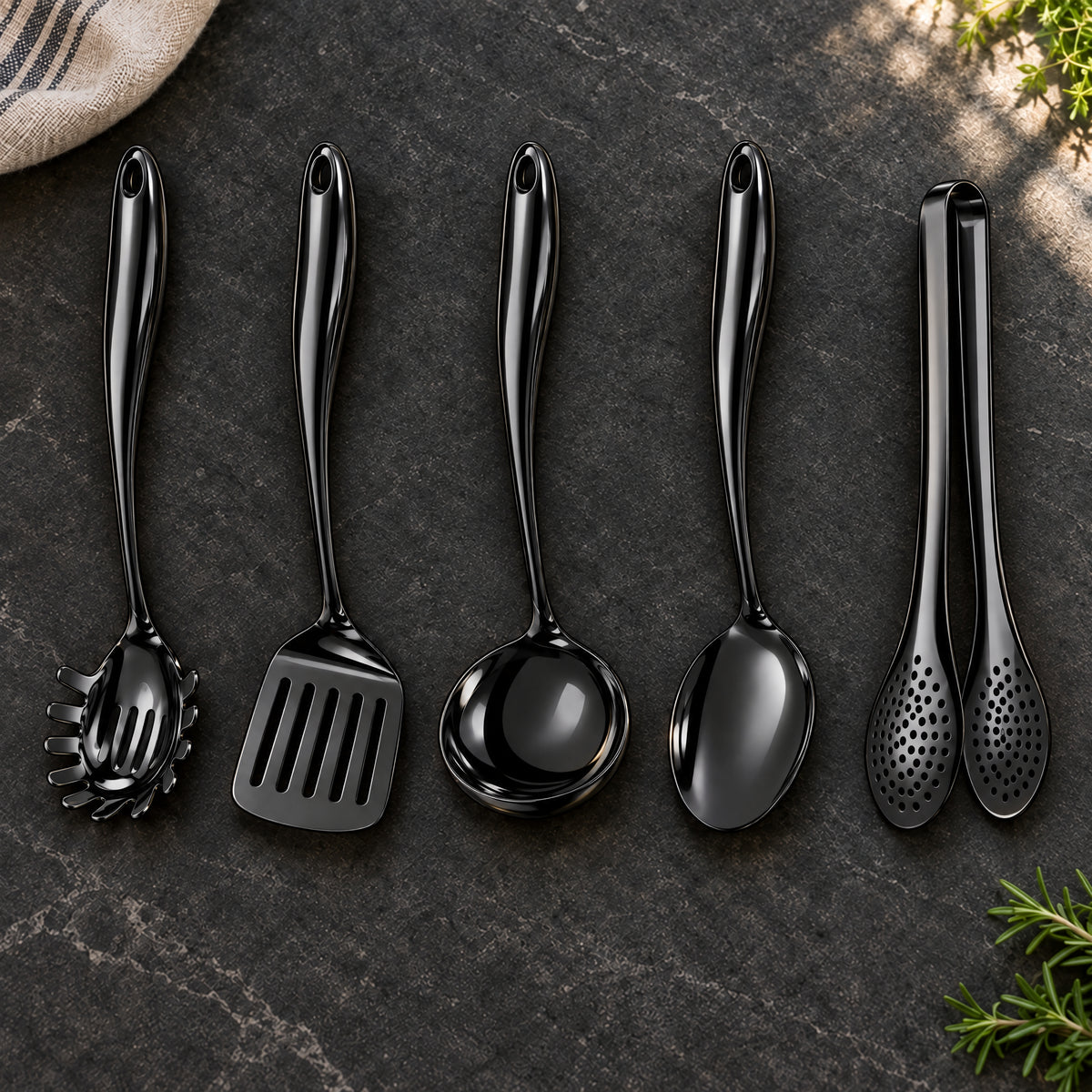 Okura 5-piece utensil set in black arranged on a charcoal kitchen countertop