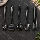 Okura 5-piece utensil set in black arranged on a charcoal kitchen countertop