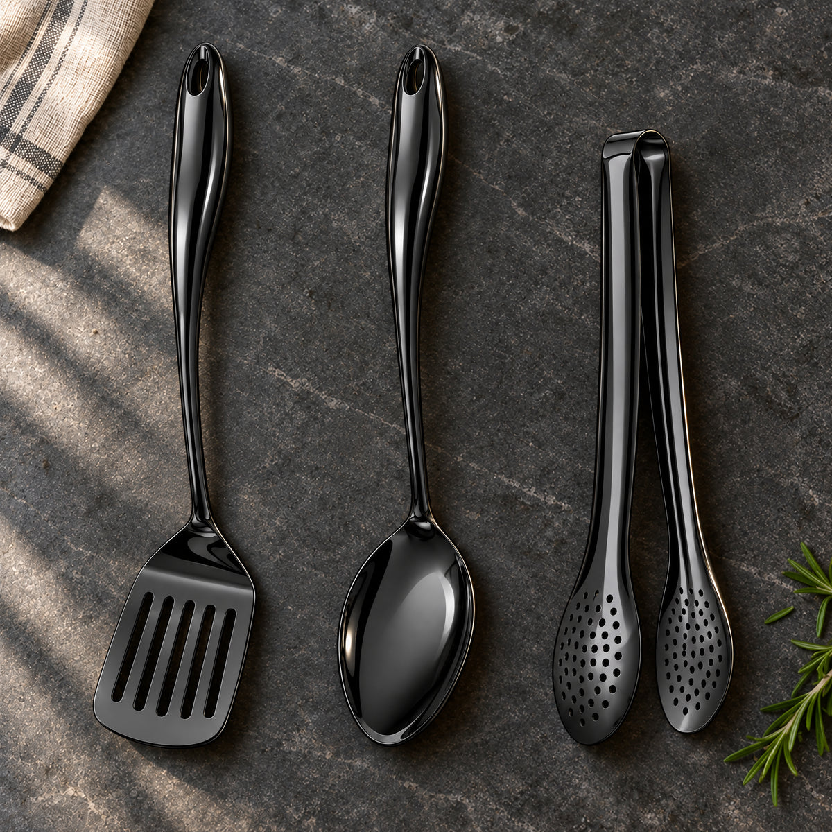 Okura 3-piece utensil set in black arranged on a charcoal kitchen countertop