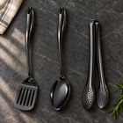 Okura 3-piece utensil set in black arranged on a charcoal kitchen countertop
