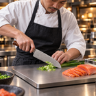 A Japanese chef using the Asahi 7-Inch Santoku Knife on a titanium cutting board in a professional kitchen