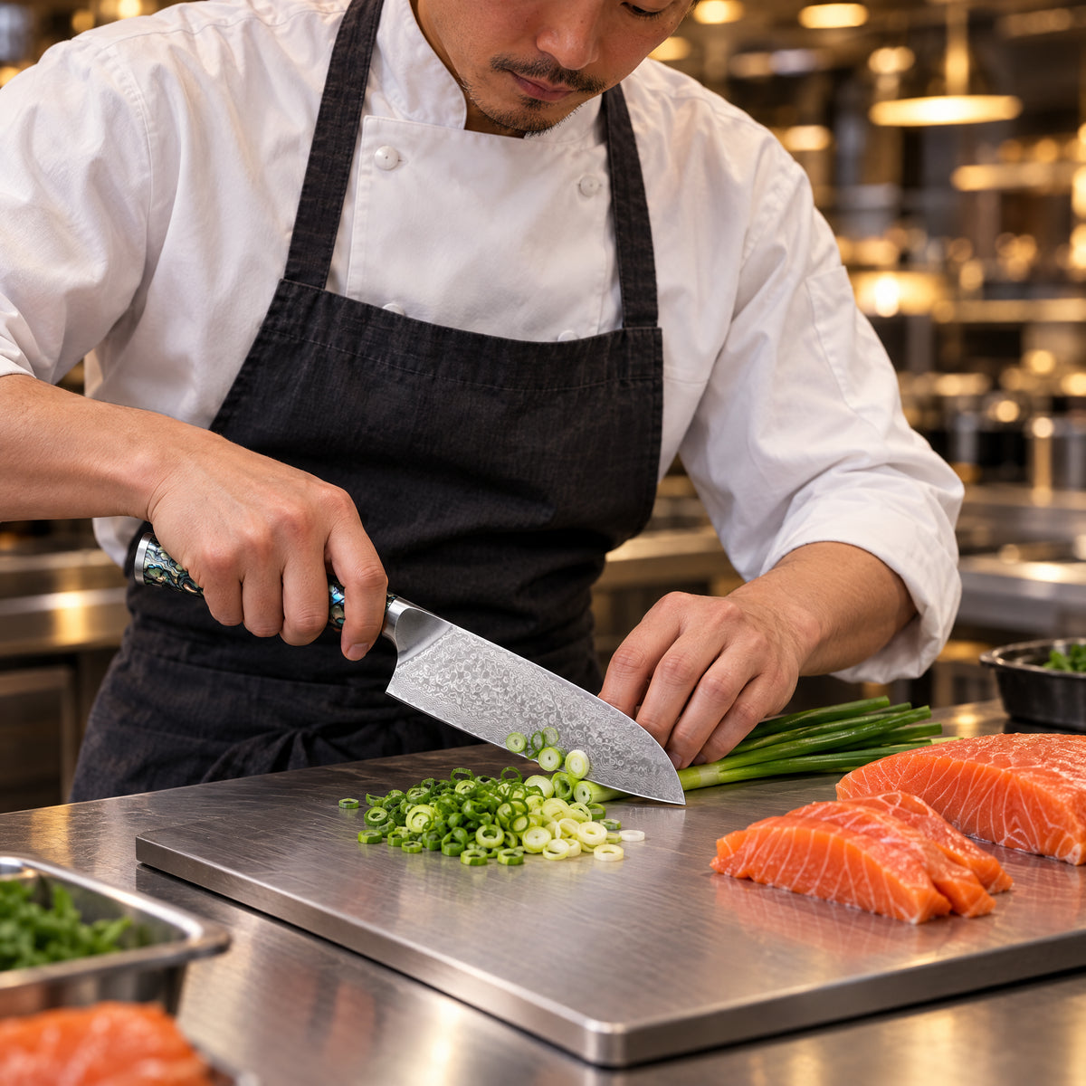 A Japanese chef using the Gekko Santoku Knife on a titanium cutting board in a professional kitchen