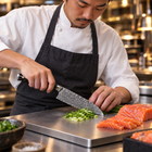 A Japanese chef using the Kogane Santoku Knife on a titanium cutting board in a professional kitchen