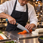 A Japanese chef using the Suijin Santoku Knife on a titanium cutting board in a professional kitchen