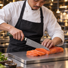 A Japanese chef using the Ibuki Gyuto Chef Knife on a titanium cutting board in a professional kitchen