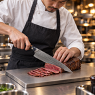 A Japanese chef using the Haku Gyuto Chef Knife on a titanium cutting board in a professional kitchen