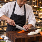 A Japanese chef using the Akagi Gyuto Chef Knife on a wooden cutting board in a professional kitchen