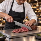 A Japanese chef using the Hakugin Kiritsuke Knife on a titanium cutting board in a professional kitchen