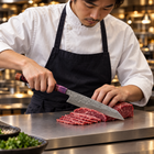 A Japanese chef using the Shinzan Kiritsuke Knife on a titanium cutting board in a professional kitchen