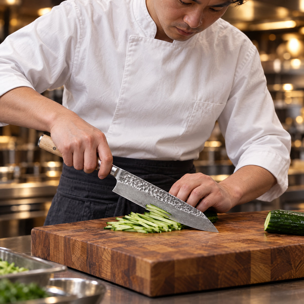A Japanese chef using the Takumi Kiritsuke Knife on a wooden cutting board in a professional kitchen