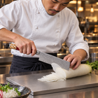 A Japanese chef using the Akagi Nakiri Knife on a titanium cutting board in a professional kitchen