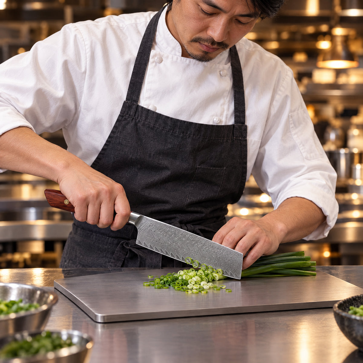 A Japanese chef using the Asama Nakiri Knife on a titanium cutting board in a professional kitchen