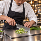 A Japanese chef using the Haku Nakiri Knife on a titanium cutting board in a professional kitchen