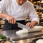 A Japanese chef using the Ibuki Nakiri Knife on a titanium cutting board in a professional kitchen