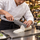 A Japanese chef using the Kongo Nakiri Knife on a titanium cutting board in a professional kitchen
