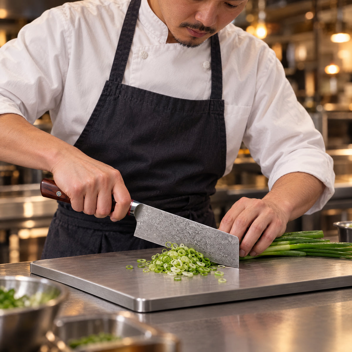A Japanese chef using the Takamori Nakiri Knife on a titanium cutting board in a professional kitchen
