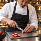 A Japanese chef using the Akagi Paring Knife on a titanium cutting board in a professional kitchen