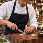 A Japanese chef using the Genkai Paring Knife on a wooden cutting board in a professional kitchen