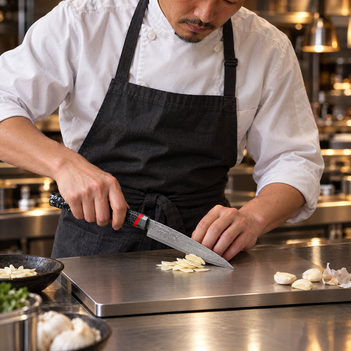 A Japanese chef using the Shingen Utility Knife on a titanium cutting board in a professional kitchen