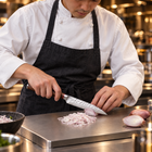 A Japanese chef using the Taiga Utility Knife on a titanium cutting board in a professional kitchen