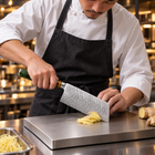 A Japanese chef using the Daigo Vegetable Cleaver Knife on a titanium cutting board in a professional kitchen