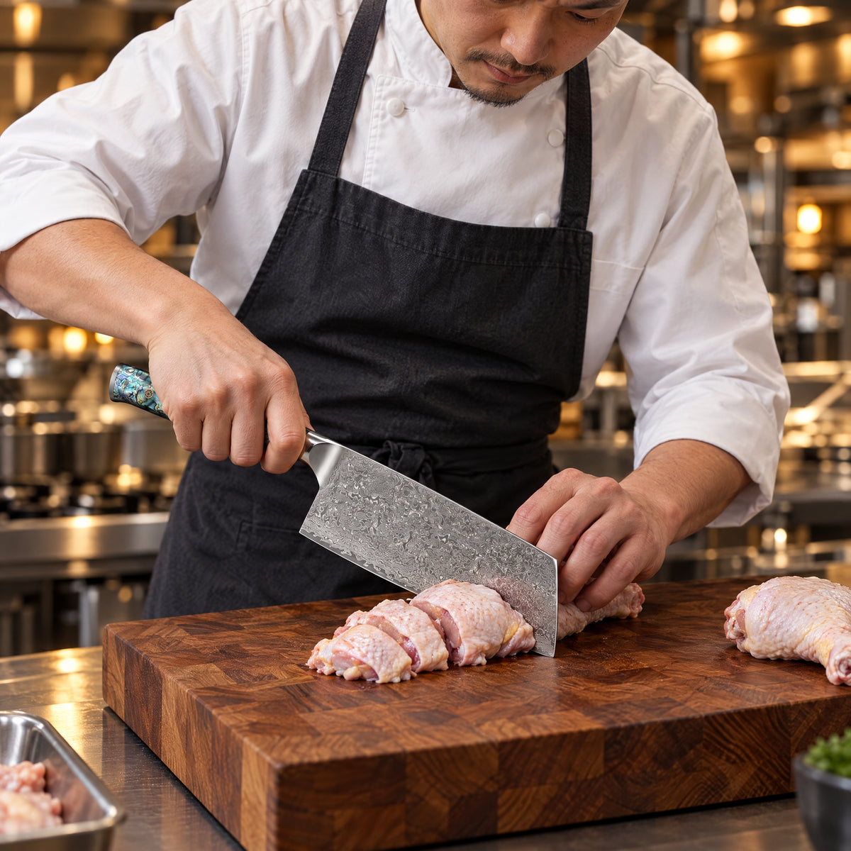 A Japanese chef using the Gekko Cleaver Knife on a wooden cutting board in a professional kitchen