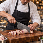 A Japanese chef using the Shingen Vegetable Cleaver Knife on a wooden cutting board in a professional kitchen
