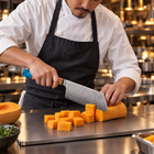 A Japanese chef using the Suijin Kiritsuke Cleaver Knife on a titanium cutting board in a professional kitchen