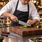 A Japanese chef using the Akitsu 3-Piece Knife Set on a wooden cutting board in a professional kitchen
