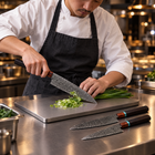 A Japanese chef using the Arashi 2-Piece Knife Set (Gyuto & Kiritsuke) on a titanium cutting board in a professional kitchen