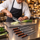 A Japanese chef using the Hagane 6-Piece Knife Set on a titanium cutting board in a professional kitchen
