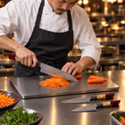 A Japanese chef using the Akatsuki 3-Piece Knife Set (Gyuto, Nakiri & Utility) on a titanium cutting board in a professional kitchen