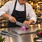 A Japanese chef using the Gekko 2-Piece Knife Set (Gyuto & Santoku) on a titanium cutting board in a professional kitchen
