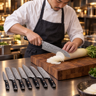 A Japanese chef using the Guren Damascus Knife Set on a wooden cutting board in a professional kitchen