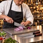 A Japanese chef using the Akitsu 2-Piece Knife Set (Gyuto & Nakiri) on a titanium cutting board in a professional kitchen