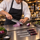 A Japanese chef using the Kazan Damascus Knife Set on a titanium cutting board in a professional kitchen