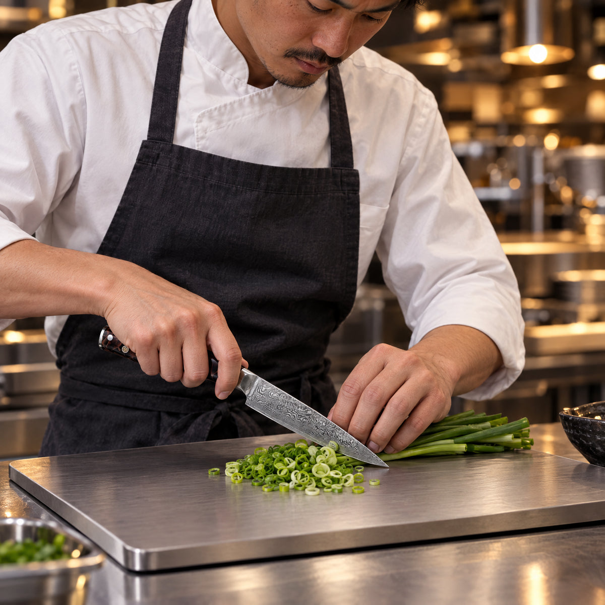A Japanese chef using the Kongo Steak Knife on a titanium cutting board in a professional kitchen