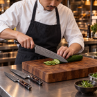 A Japanese chef using the Kongo 2-Piece Knife Set (Gyuto & Utility) on a wooden cutting board in a professional kitchen