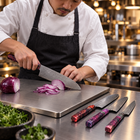 A Japanese chef using the Shinzan Damascus Knife Set on a titanium cutting board in a professional kitchen