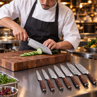 A Japanese chef using the Taiga 7-Piece Knife Set on a wooden cutting board in a professional kitchen