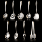 Okura 9-piece utensil set, rounded handles, black studio with subtle warm lighting