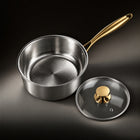 The hammered titanium interior of the Limited Edition saucepan with the glass lid beside it