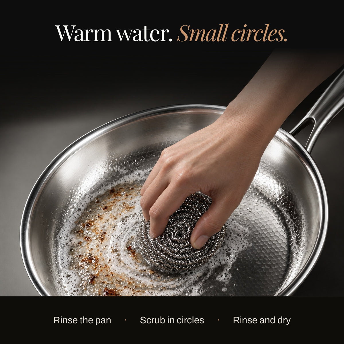 Hand scrubbing an Okura titanium pan in small circles with warm water
