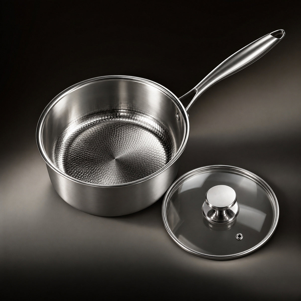 The hammered titanium interior of the saucepan with the glass lid beside it
