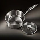The hammered titanium interior of the saucepan with the glass lid beside it