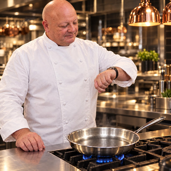Chef Gregory preheating an empty Okura hammered titanium pan and checking his watch