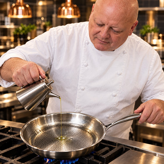 Chef Gregory adding a thin stream of oil to an Okura hammered titanium pan